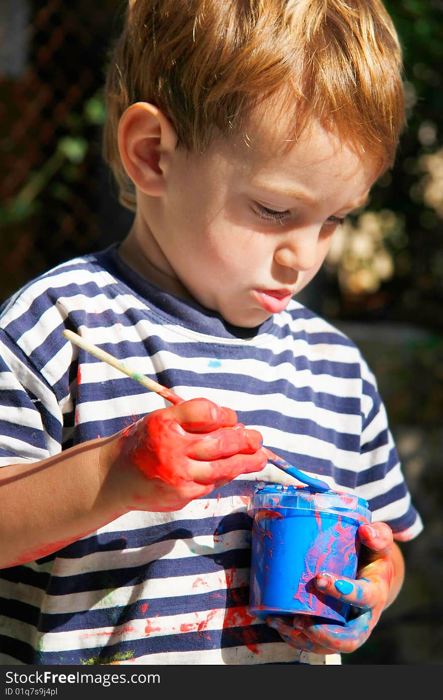 Young boy ready to paint outdoors portrait