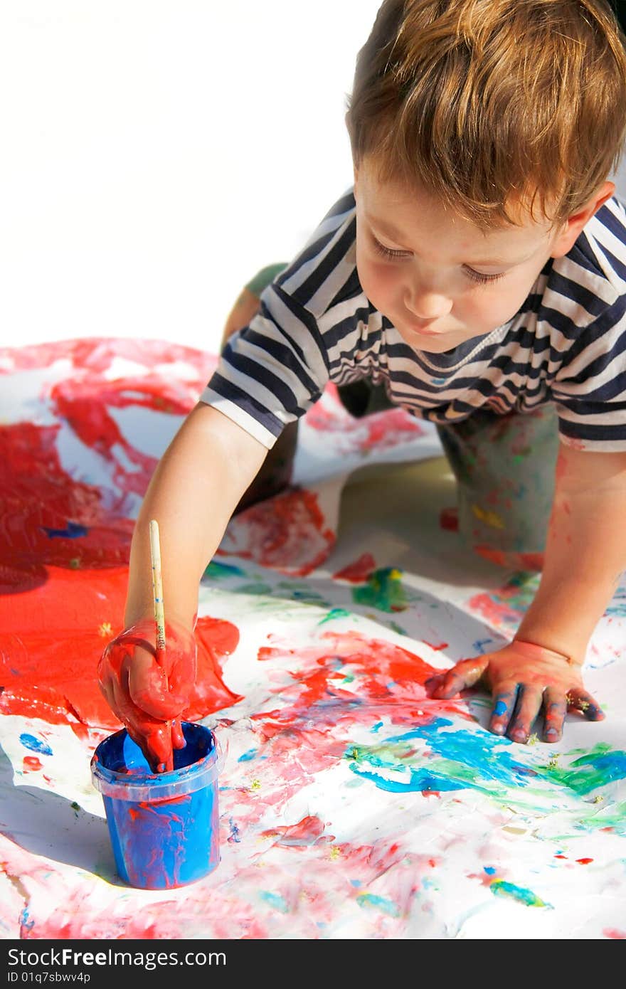 Young boy painting over white