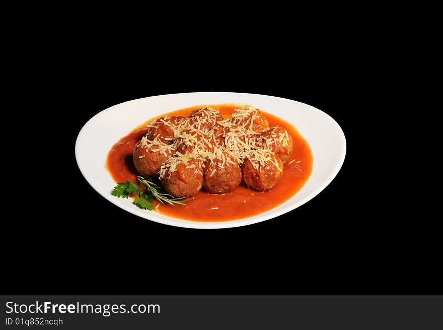 Meatballs with sauce and grated cheese, white plate, background black