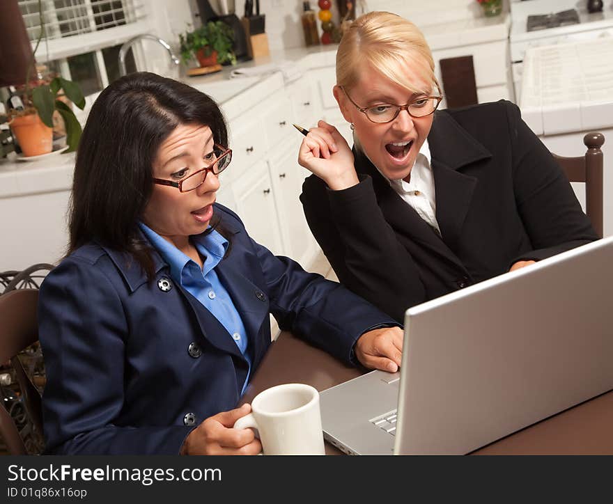 Businesswomen Celebrate Success on the Laptop in the Kitchen.