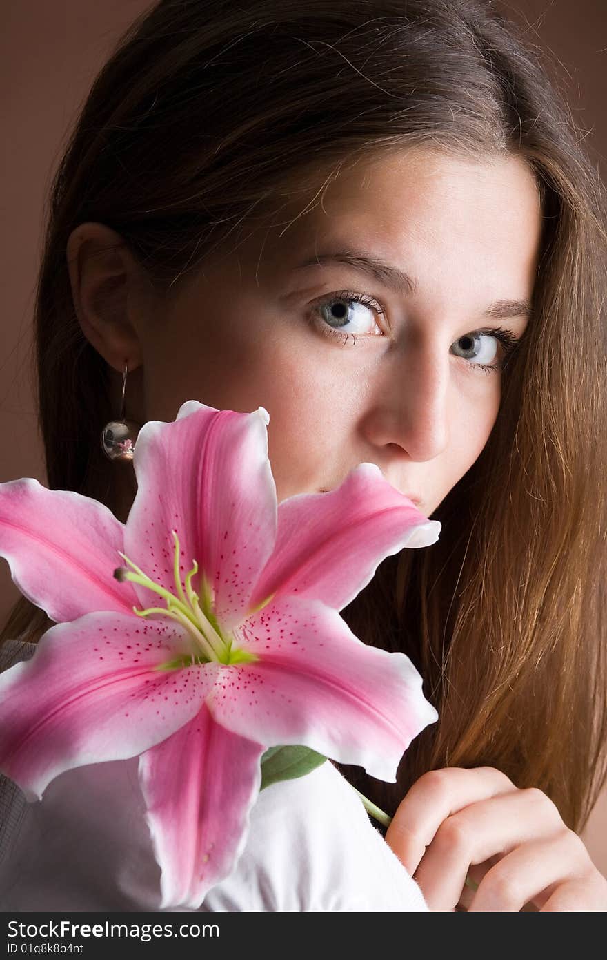 Young woman posing with a pink lily