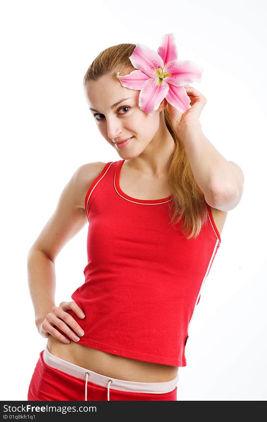 A nice blond girl in red posing with a pink lily near her face on a white background. A nice blond girl in red posing with a pink lily near her face on a white background