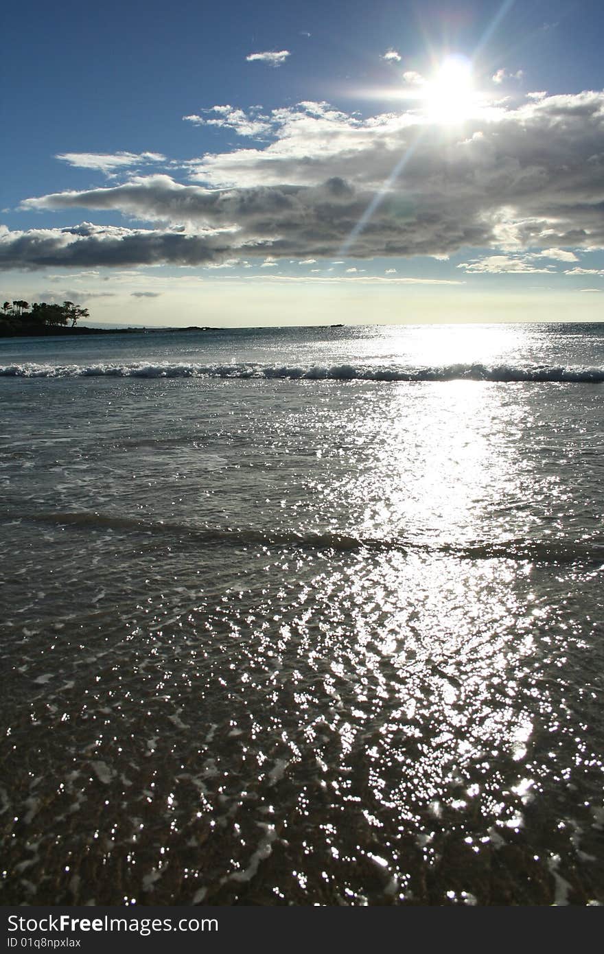 Sun peeks out behind clouds glistening off the surf on Hawaii's big island. Sun peeks out behind clouds glistening off the surf on Hawaii's big island...