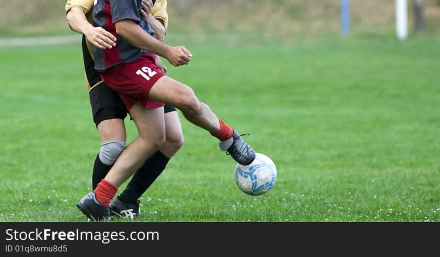 Soccer players running after the ball