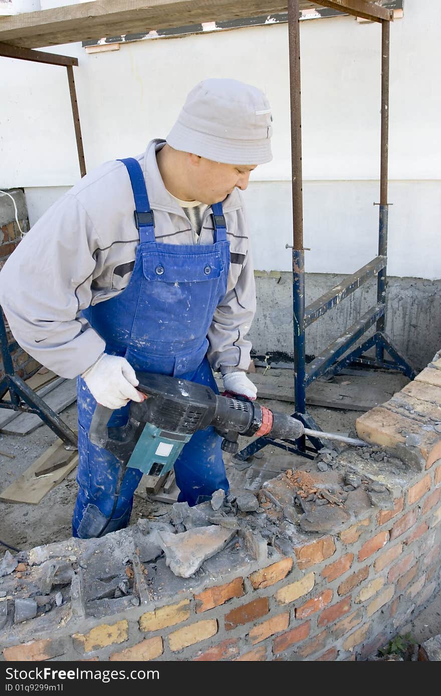 Builder destroys brick wall a jackhammer