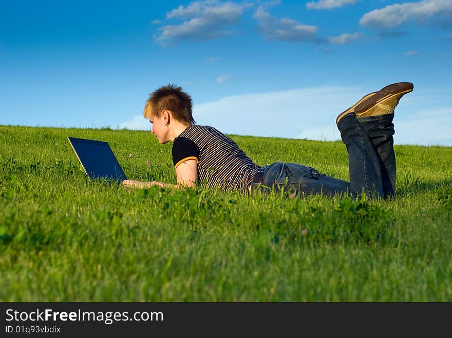 Young girl on a green grass with laptop. Young girl on a green grass with laptop