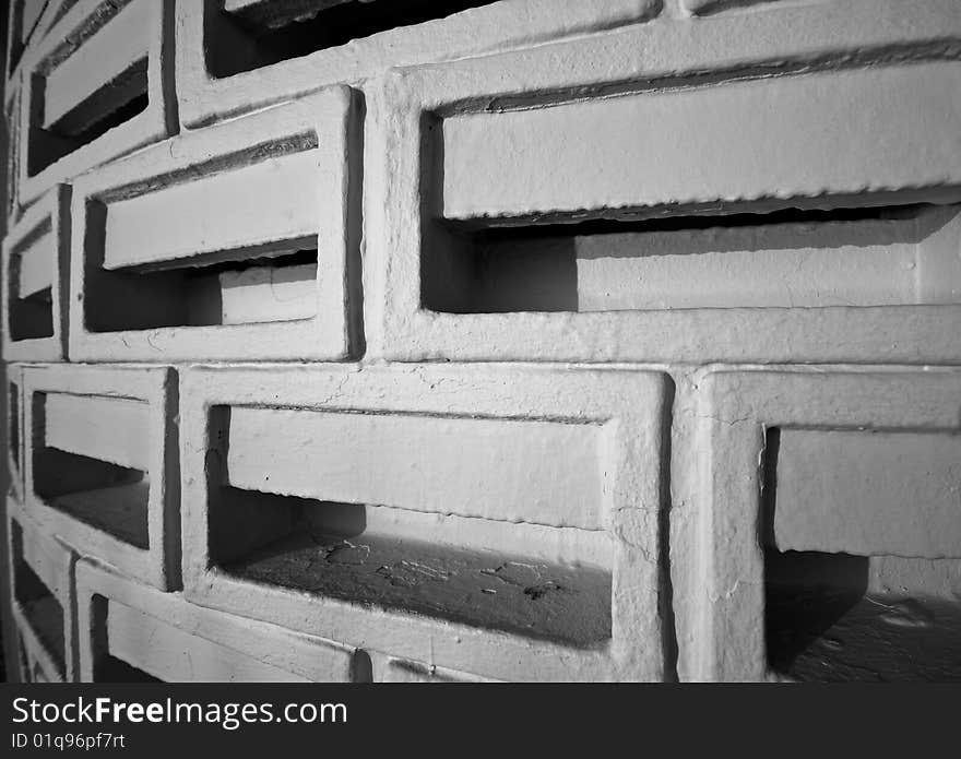 A circular wall made of ventilated bricks in black and white. A circular wall made of ventilated bricks in black and white