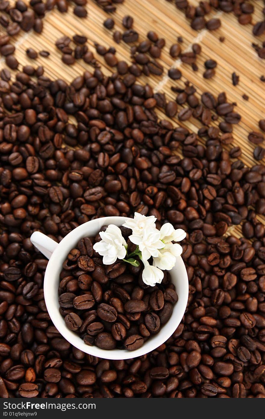 Coffee cup with beans and a white flower. Coffee cup with beans and a white flower