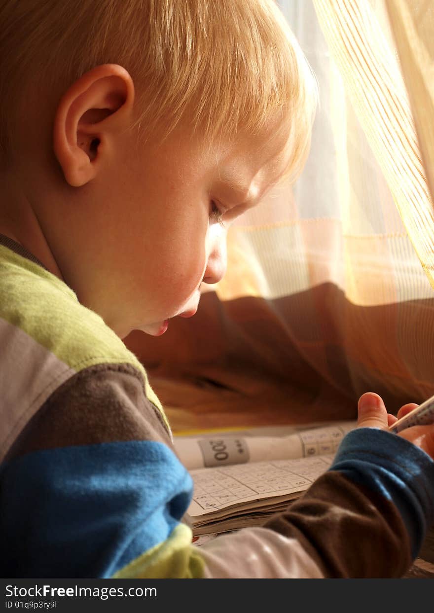 A small boy wrote in pencil on the window