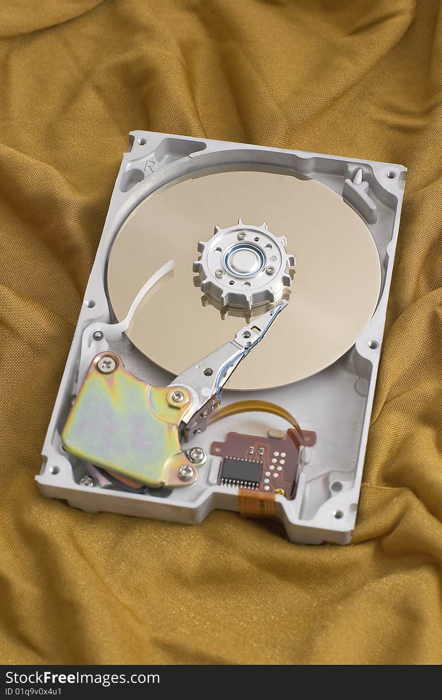 Open harddisk on golden fabric background