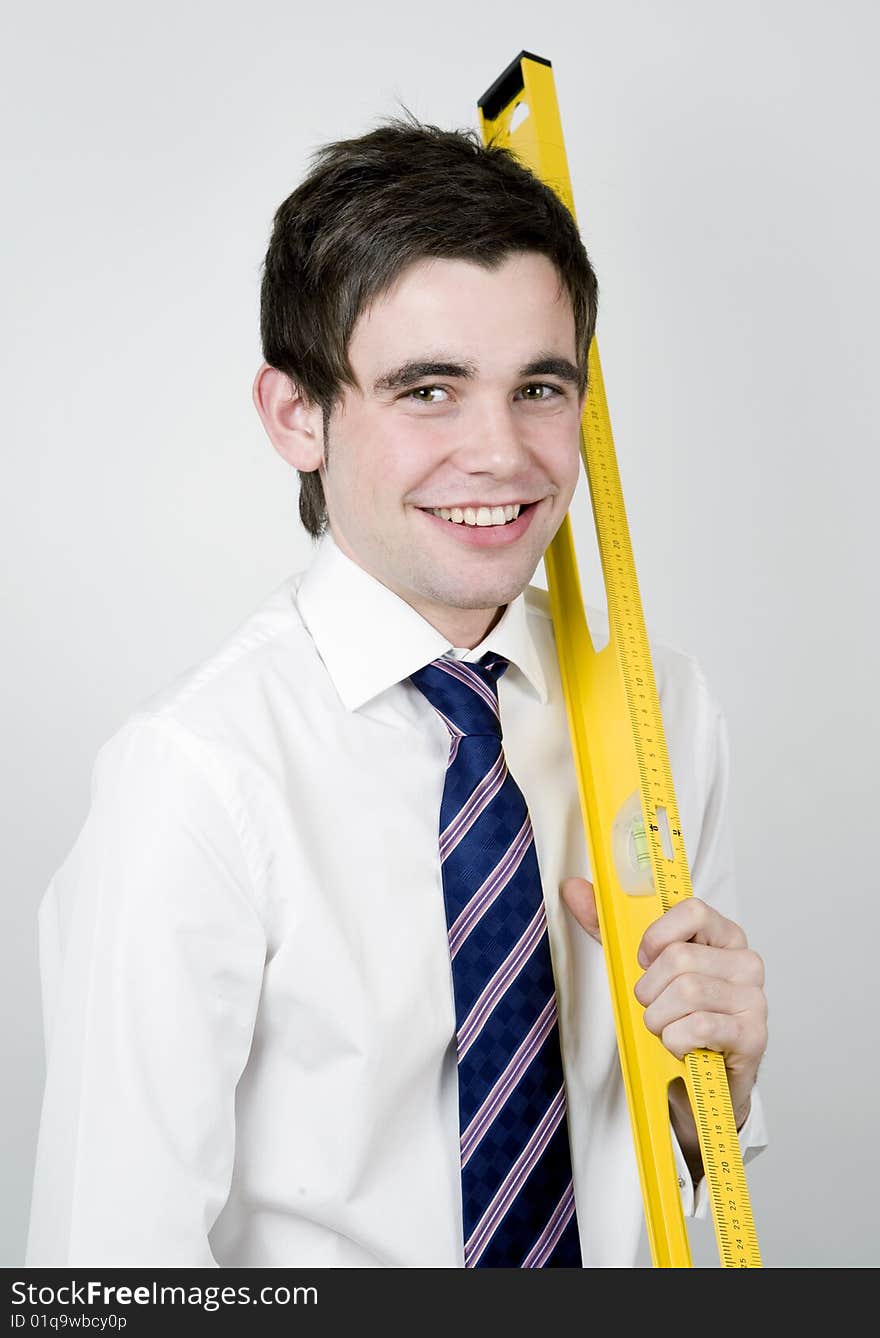 Young office worker holds a yellow ruler. Young office worker holds a yellow ruler