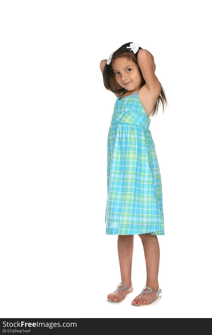 Cute young girl in blue dress with arms up