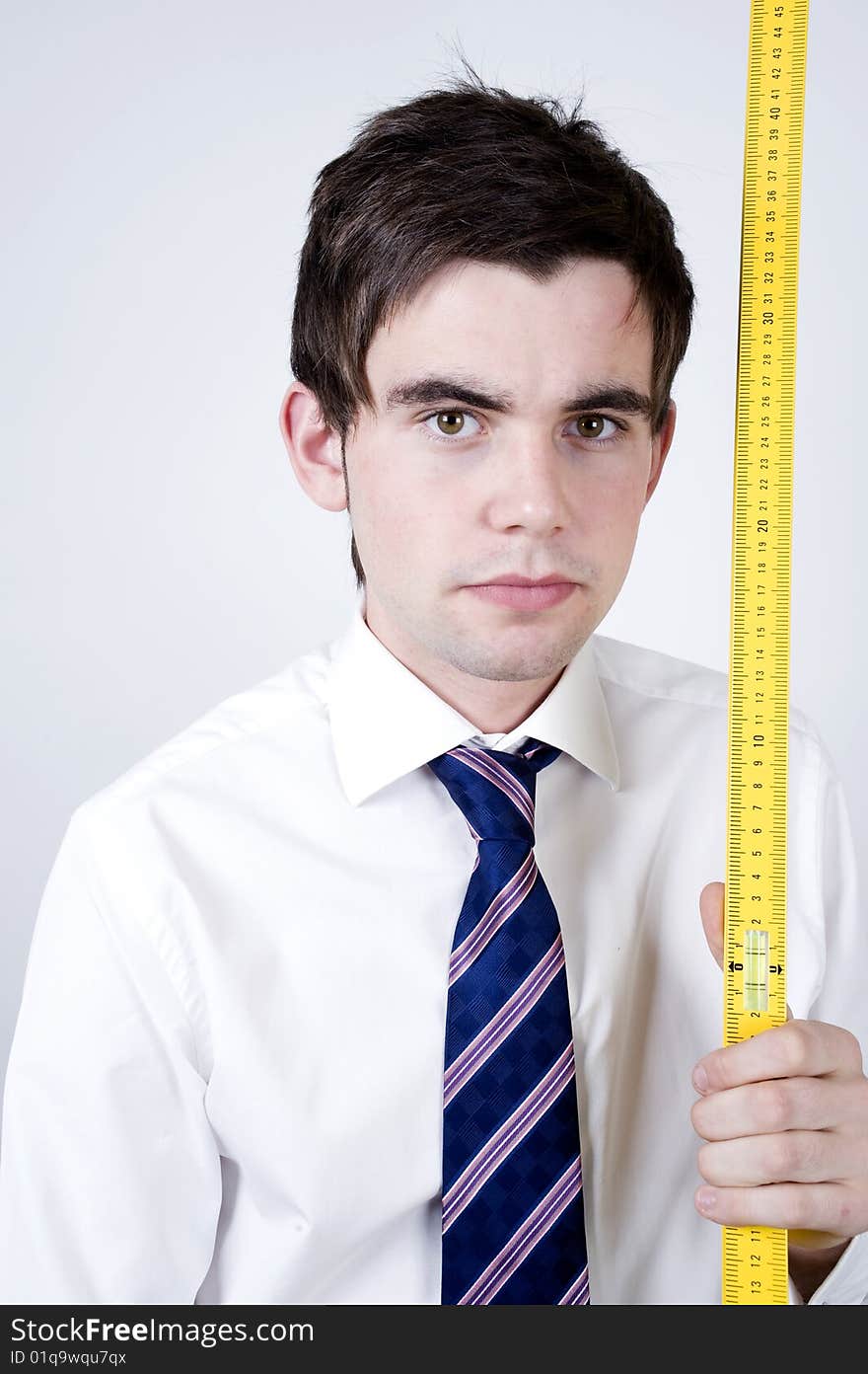 Young office worker holds a yellow ruler. Young office worker holds a yellow ruler