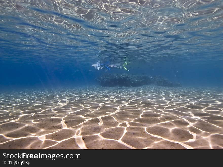 People on the surface of a tropical sandy bay