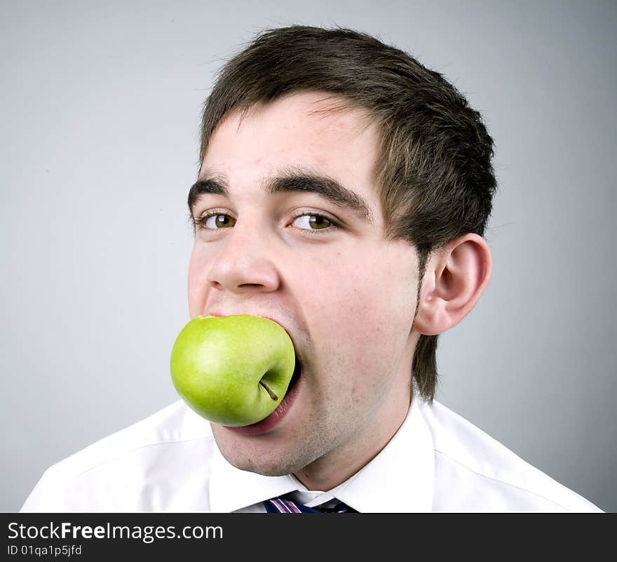 Young man eats a fresh green apple. Young man eats a fresh green apple