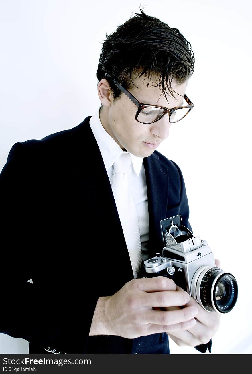 Stylish gentleman holds vintage camera while wearing suit. Stylish gentleman holds vintage camera while wearing suit