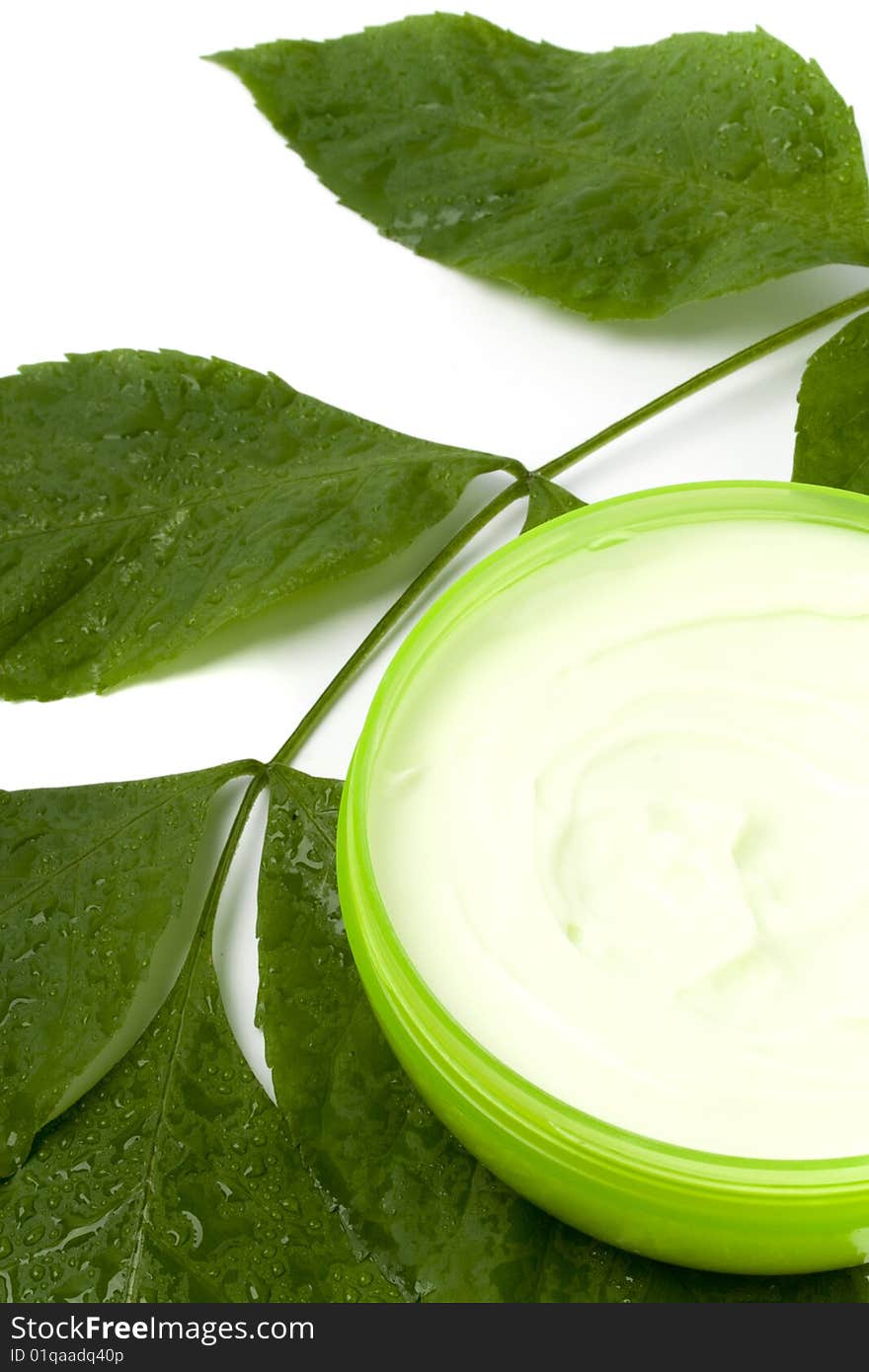 Face cream with green leaf on white background