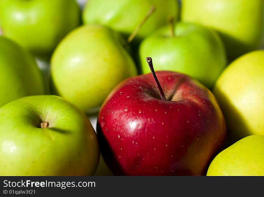 Red apple between green apples