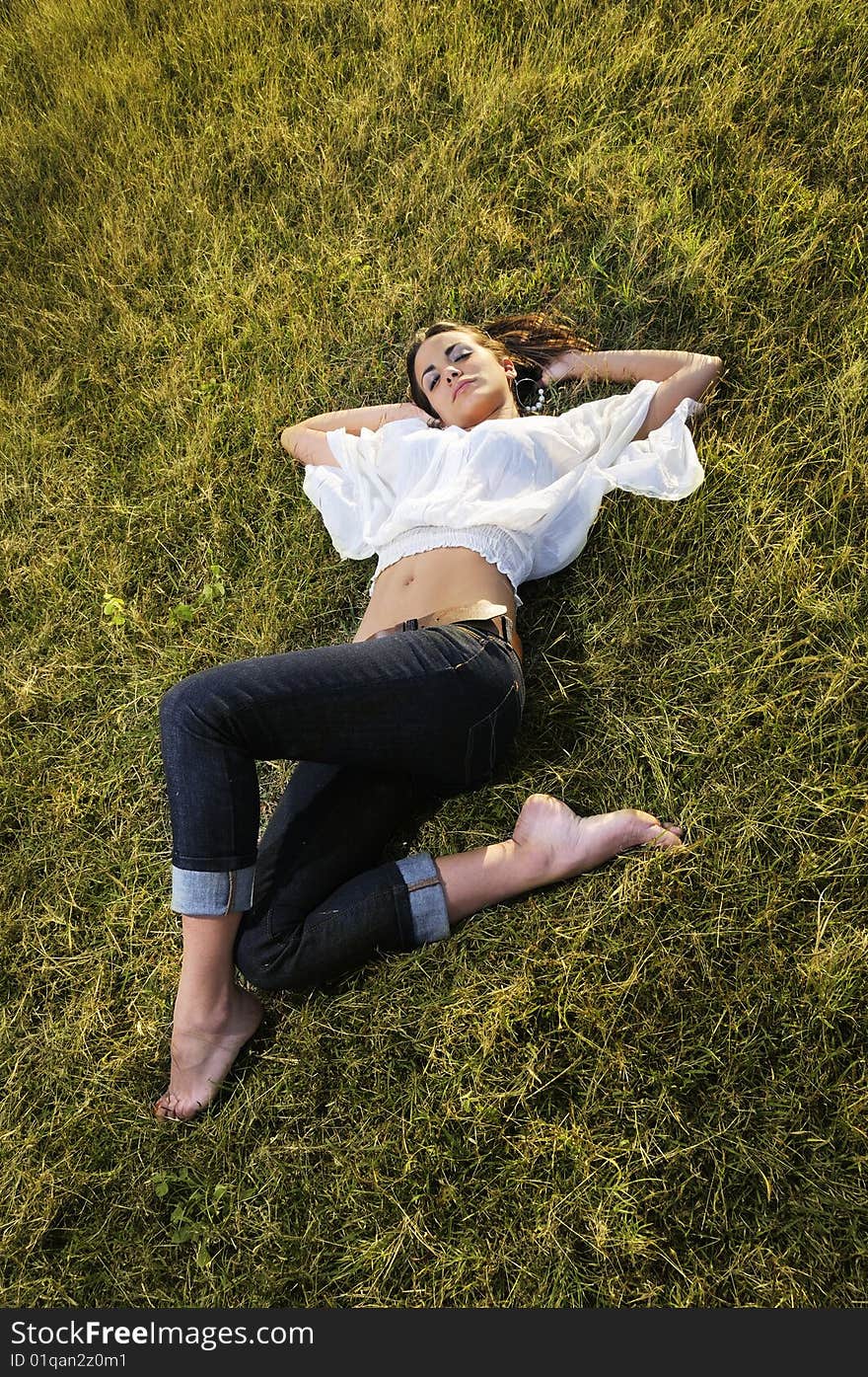 Portrait of young female beauty lying on the grass. Portrait of young female beauty lying on the grass