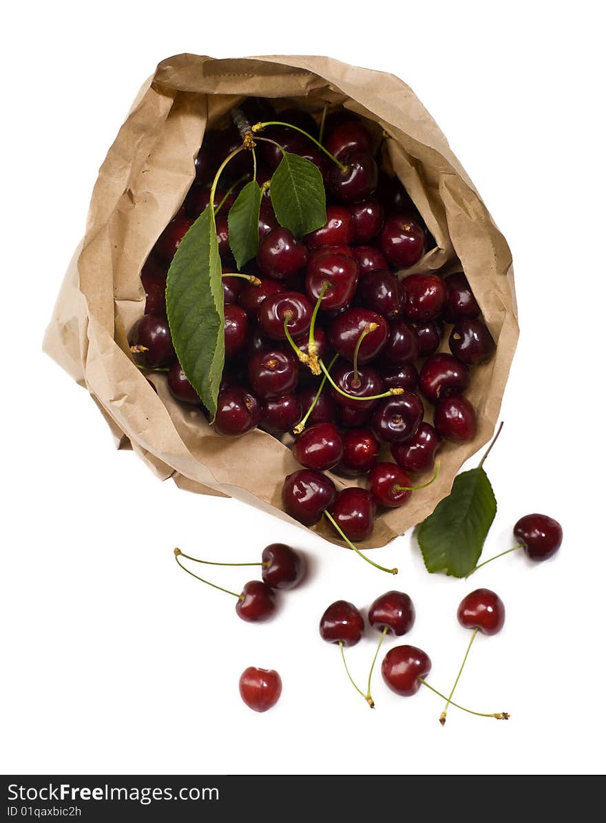 Fresh red cherry rolling out from a paper bag with white background