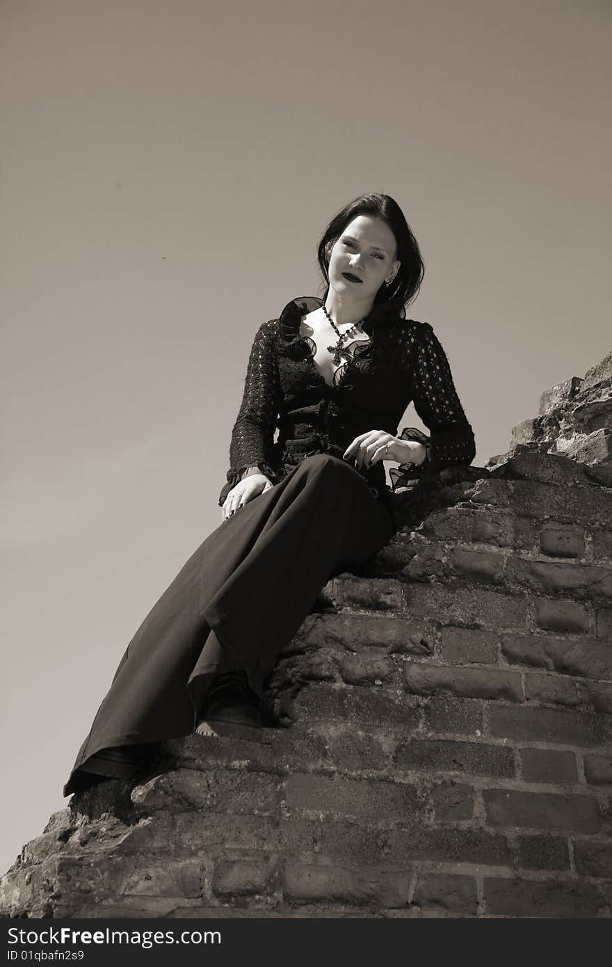 Young gothic girl and ruins of castle