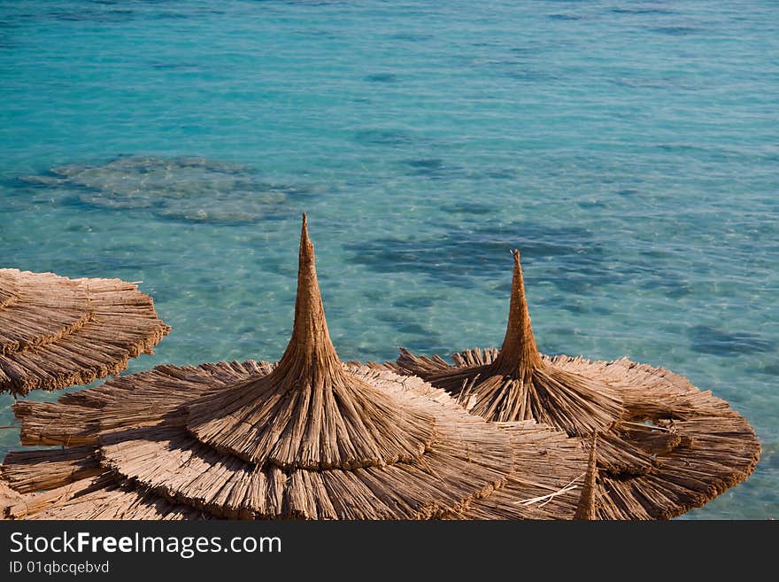 Beach umbrellas and blue sea with corals