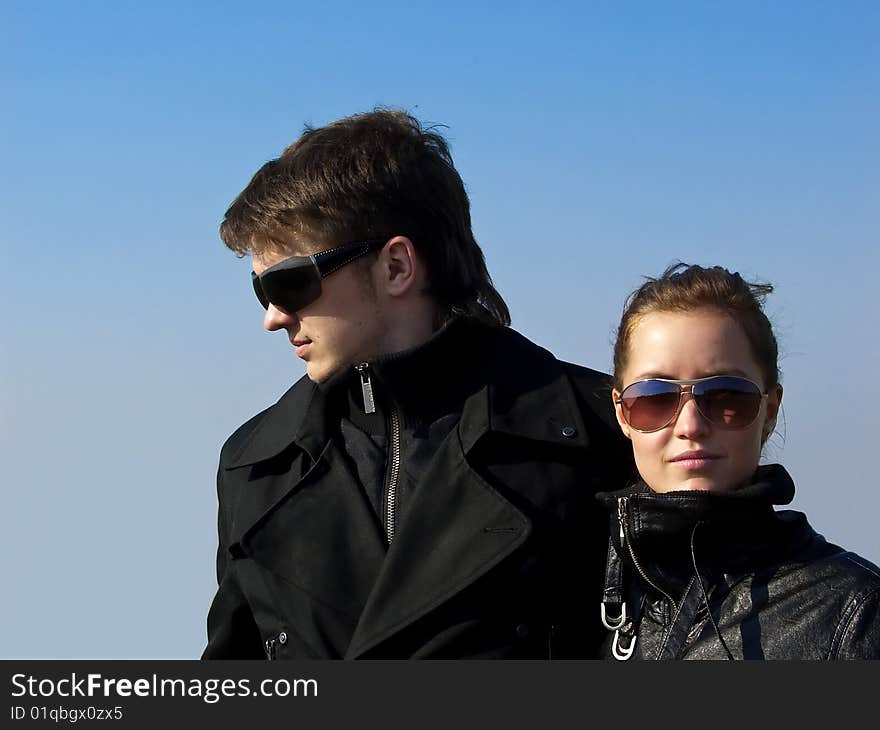 Young couple in the black jacket and sunglasses