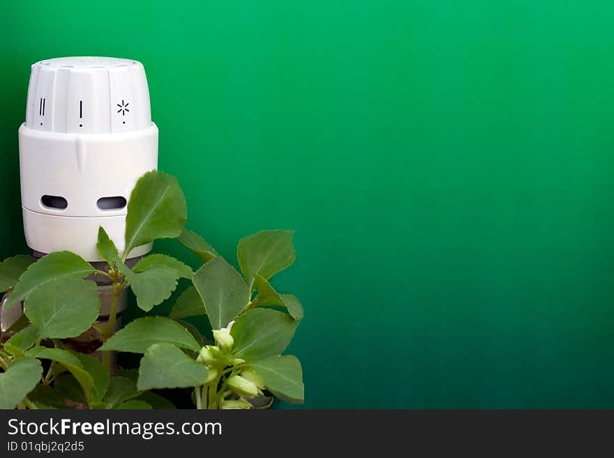 Radiator thermostat with green graduated background and plants. Radiator thermostat with green graduated background and plants