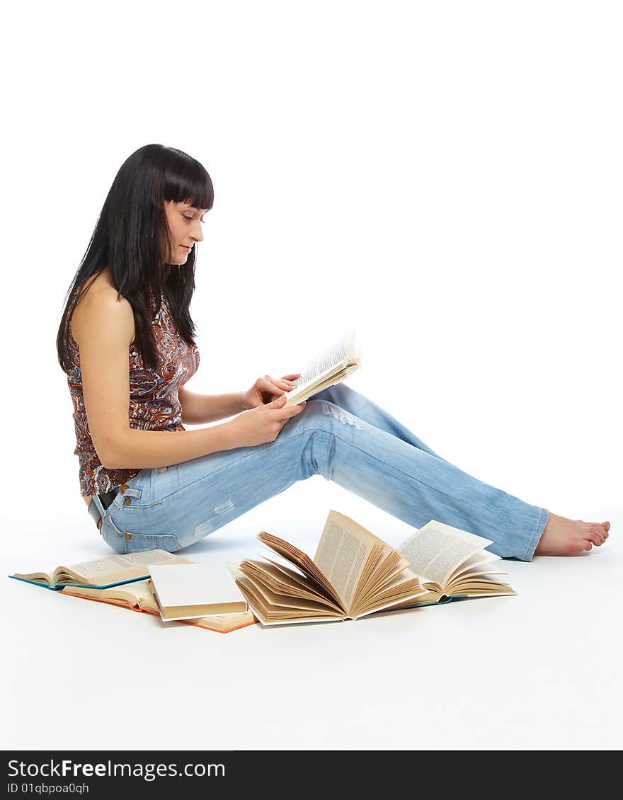 Girl sitting on the floor and reading book. Isolated on white background