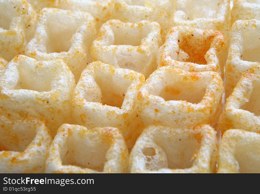 Snack and junk food crispy potato chips in the form of cubes with red pepper