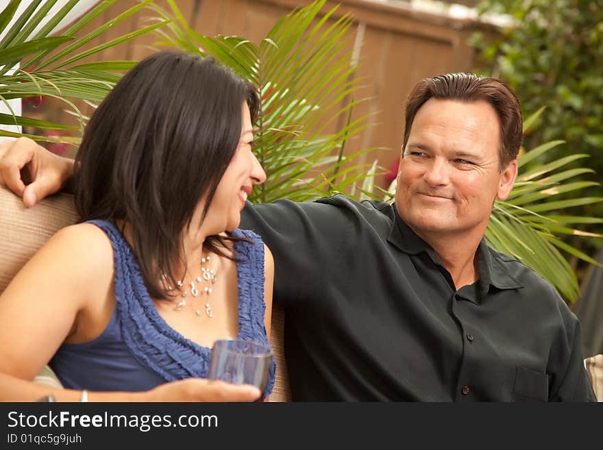 Attractive Hispanic and Caucasian Couple Drinking Wine Outside.