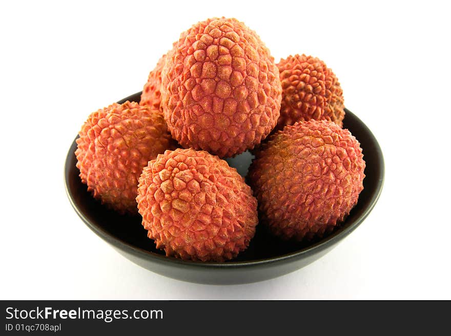 Group of lychee in a black dish with clipping and a white background