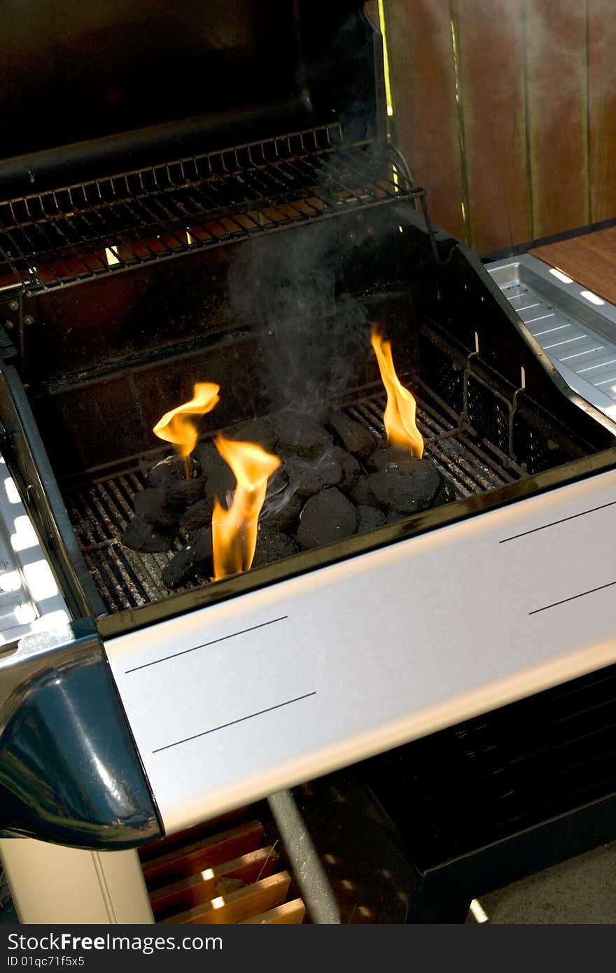 Chrome and blue Barbecue fire with orange flames and black charcoal