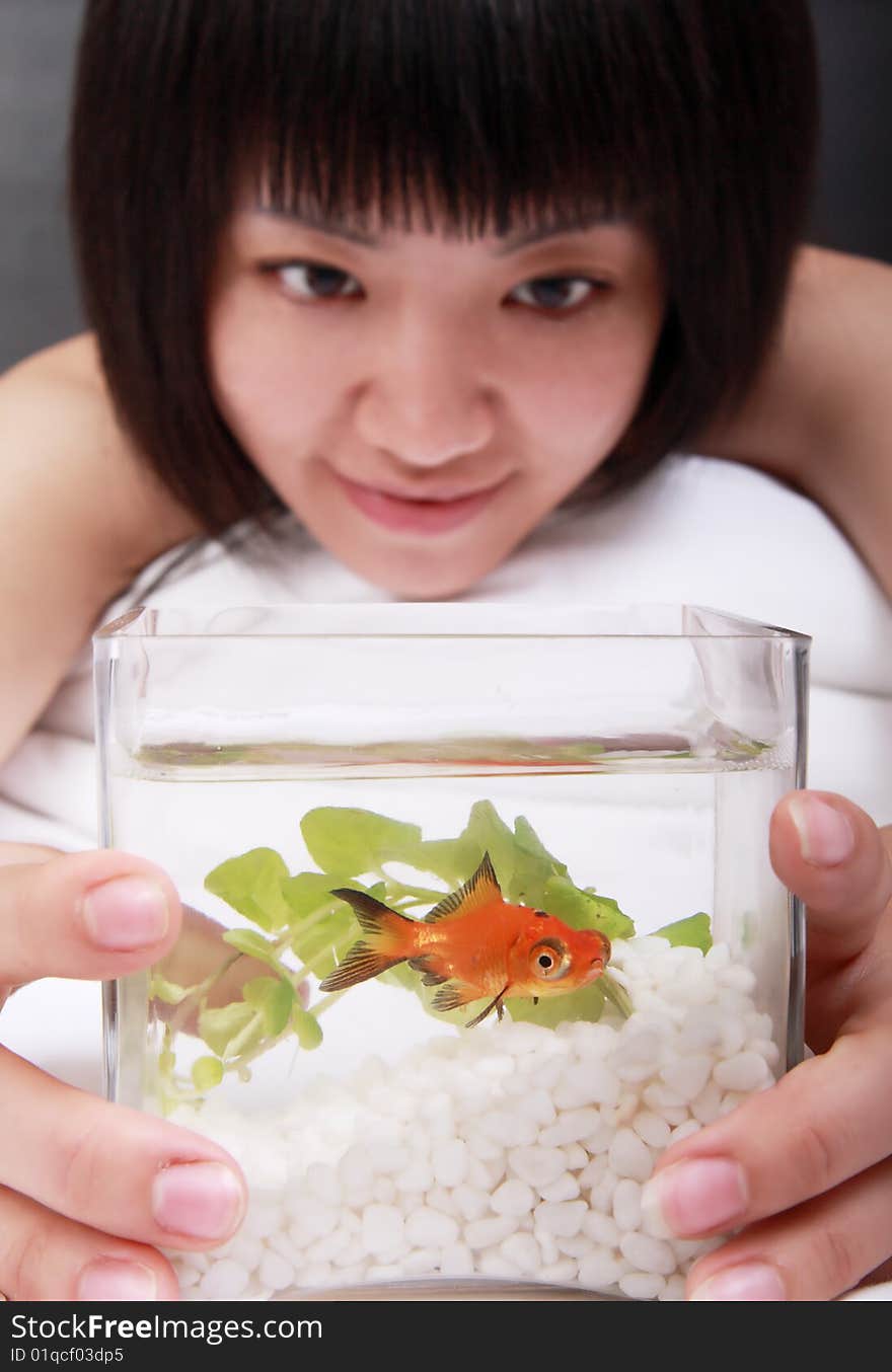 A beautiful Asian girl is attracted by her goldfish.

The focus is in the goldfish. A beautiful Asian girl is attracted by her goldfish.

The focus is in the goldfish.