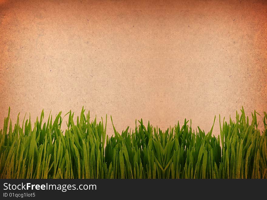 Green grass against a grungy toned paper background