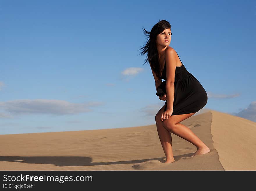 Young beautiful woman on sand in a windy day. Young beautiful woman on sand in a windy day