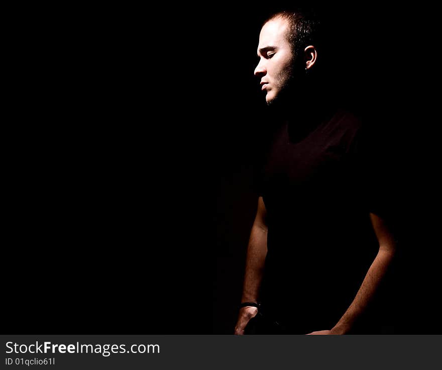 Young man over black background. Space to insert text or design.