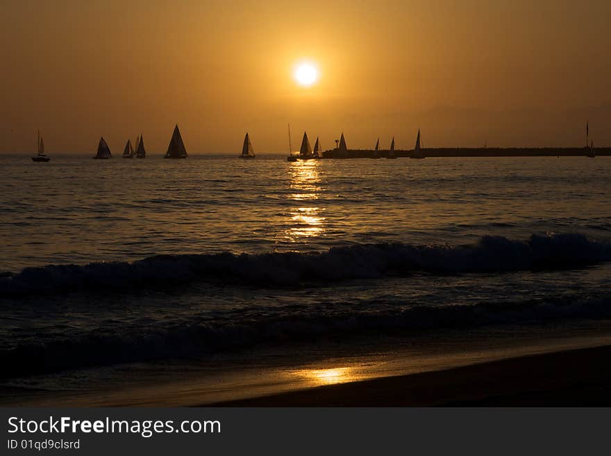 Several sailboats sail through the sunset and reflection. Several sailboats sail through the sunset and reflection