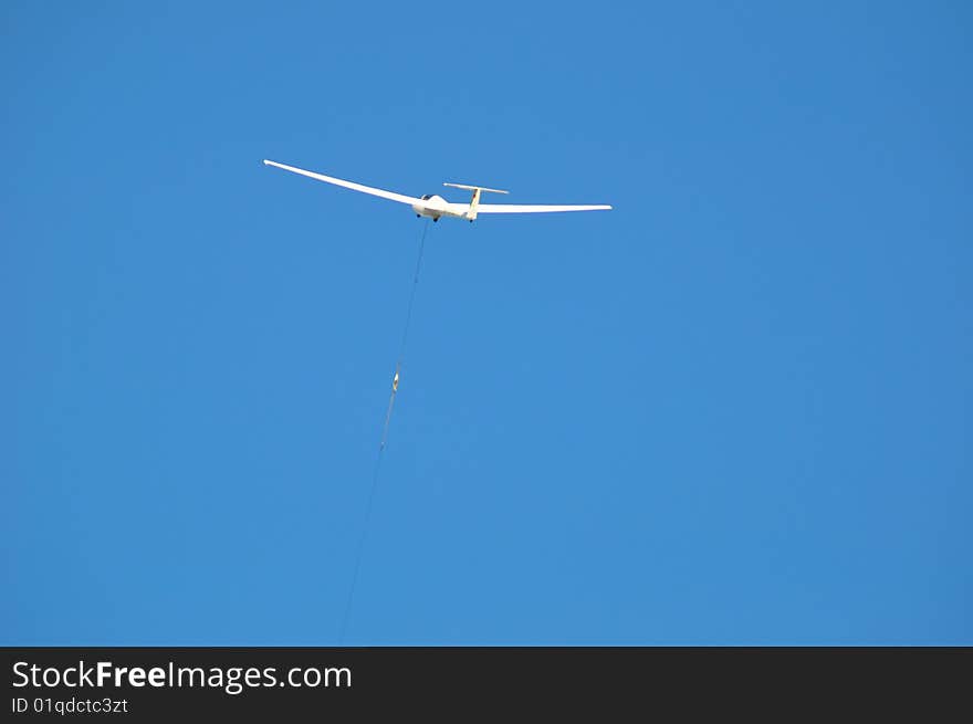 A sailplane against blue sky with white summer clouds