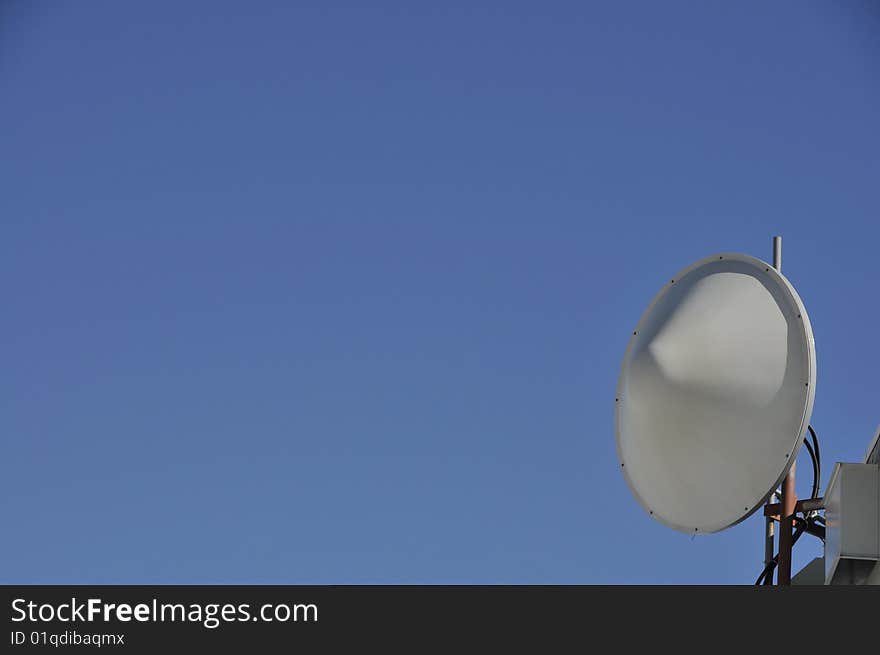 Remote Microwave Antenna on Top of Mountain Peak Against Blue Sky. Remote Microwave Antenna on Top of Mountain Peak Against Blue Sky