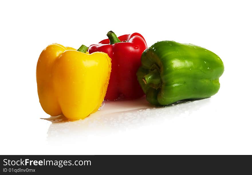 Three fresh peppers under pouring water isolated over a white background