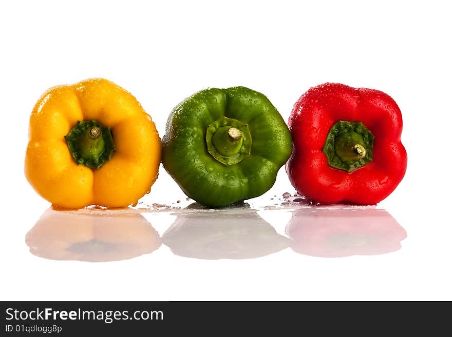 Three fresh peppers under pouring water isolated over a white background