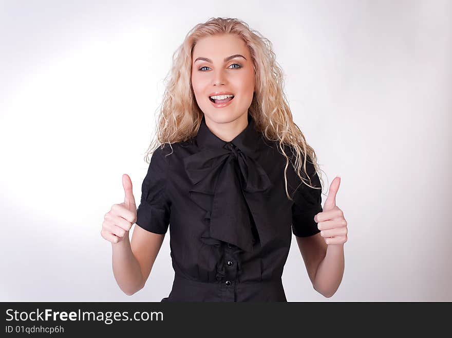 A beautiful girl gives a thumbs up, studio shot