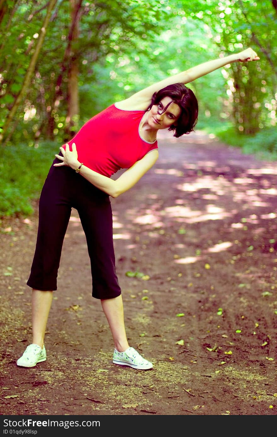 Sporty woman working out on a forest path.