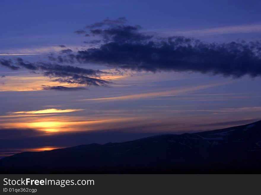 Cloudy sky and mountains on sunset