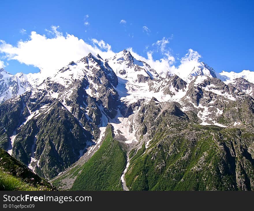 Snowy Peaks Of Mountains In Summer