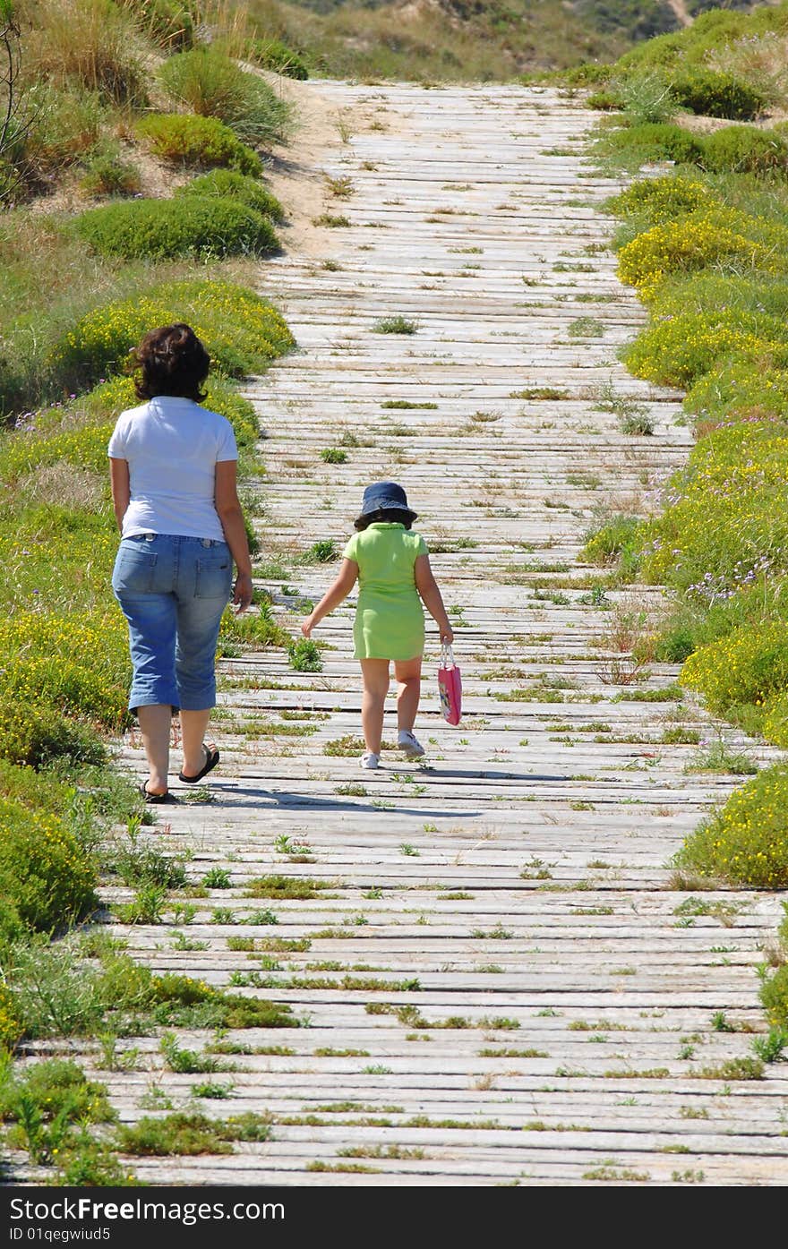 Mother and is daughter walking near the beach