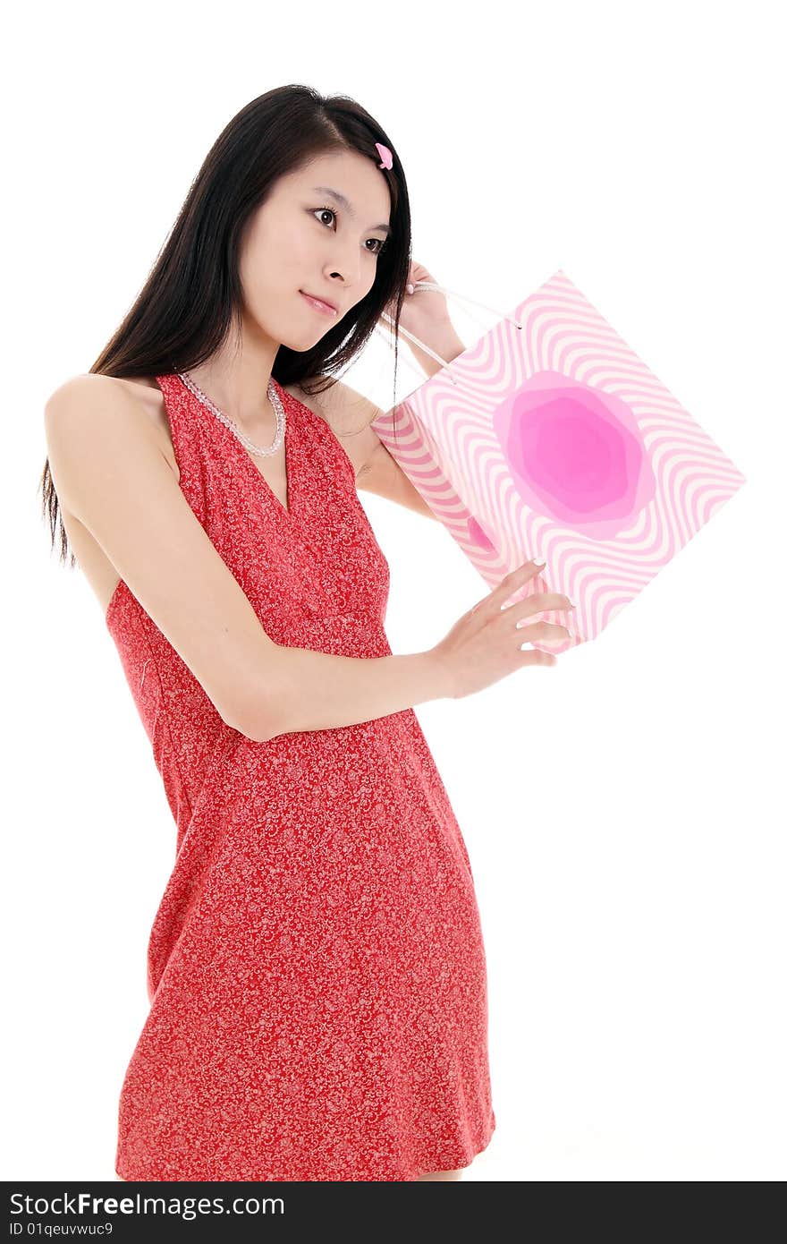 A beautiful Asian girl holds a shopping bag on white background. A beautiful Asian girl holds a shopping bag on white background.