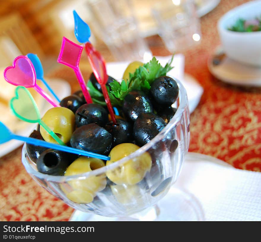 Black olives and parsley in a vase