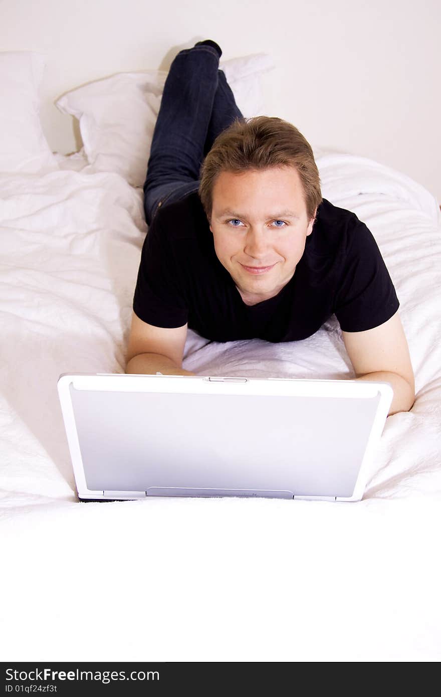 Man using laptop on bed